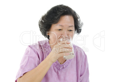 Senior woman drinking milk with glass