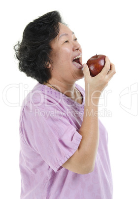 Asian Senior adult woman eating apple
