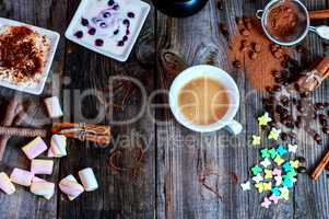 cup of black coffee with a dessert on the gray wooden surface