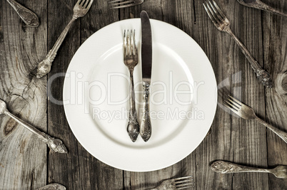 White empty plate on a gray wooden surface