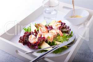 Avocado shrimp salad with mustard sauce on a tray