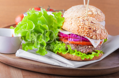 Cheeseburger with salad, onion tomato and fresh bread.