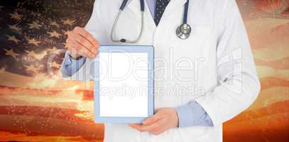 Composite image of doctor showing a digital tablet