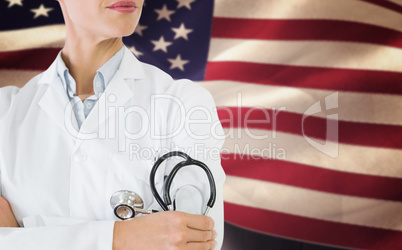 Composite image of mid section of a female doctor with stethoscope in hospital