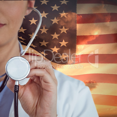 Composite image of close-up of female doctor holding stethoscope