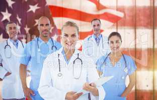 Composite image of confident female doctor with team over white background