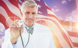 Composite image of happy doctor smiling at camera and showing his stethoscope