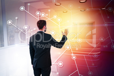 Composite image of rear view of businessman pretending to touch invisible screen