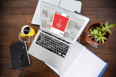 Composite image of overhead view of office desk with laptop and documents