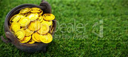 High angle shot of golden coins in bucket