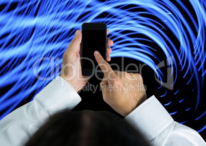 Composite image of hand touching cell phone screen against blue lights