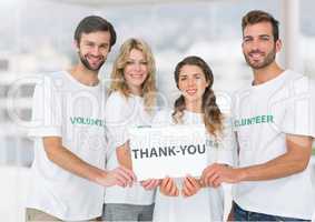 Happy Volunteer group showing Thank you sign against a light background