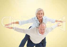 Happy Senior Couple having Fun against a yellow background