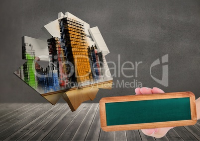 Composite image of Hand holding board against city architecture