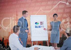 Business Team Standing and Speaking in front of Graph against an orange background