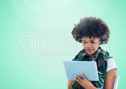 Woman using tablet against a light green background