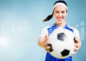 Composite image of a sports woman holding a foot ball against blue sky