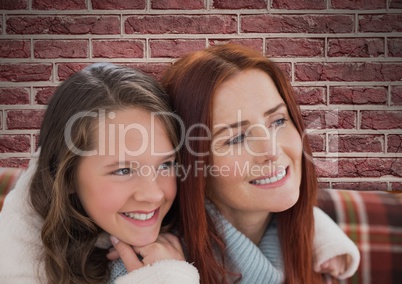 Composite image of mother with her daughter against bricks wall