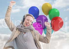 Happy Woman listening music with balloons against a sky background