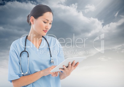 Doctor Woman using Tablet against Sky background
