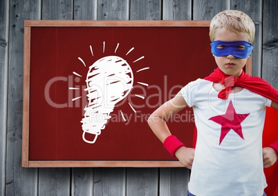 kid and blackboard with lightbulb against a wood background