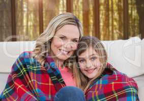 Mother and Daughter with blanket against a neutral background