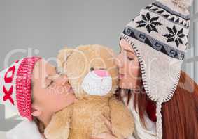 Mother and Daughter Kissing a Teddy Bear against a neutral background