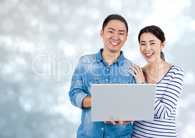 Happy Couple using Laptop against a shining grey background