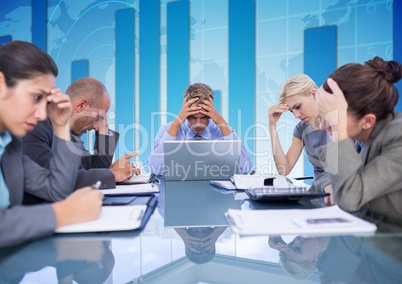 Business Team Seating around table looking at working paper against blue background