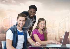 Group of friends using laptop and smiling against a city background