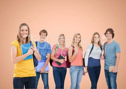Happy group of student smiling at camera against a orange background