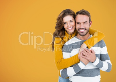 Happy Couple Hug and smilling at camera against a Yellow Background