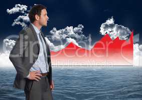 Businessman Standing in front of Graph against a sea and sky background
