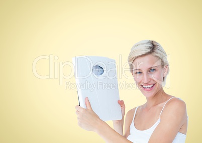 Woman holding Weight scales against a yellow background