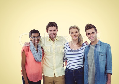 Happy group of young people smiling at camera against a yellow background