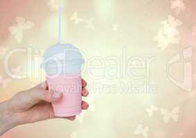 Composite image of Hand holding Milkshake Smoothie against Butterflies background