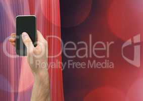 Composite image of Hand holding a mobile phone against a red background