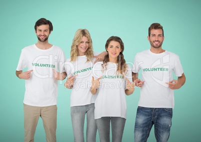 Happy Volunteers Teams pointing at tee shirt against green background