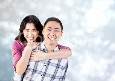 Happy Couple Hug and smilling at camera against a grey Background