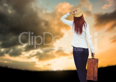 Woman holding Luggage against sky background