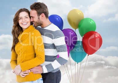 Happy couple with balloons against a sky background