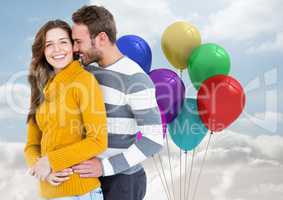 Happy couple with balloons against a sky background