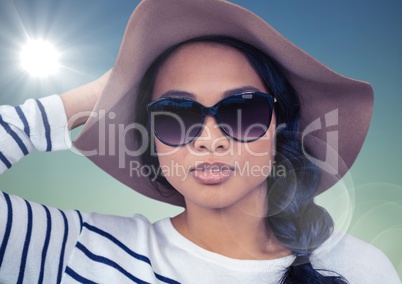 Woman in summer hat against blue background with flare