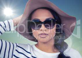 Woman in summer hat against blue background with flare