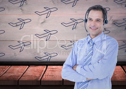 Travel agent with headset against a wood background with blue planes