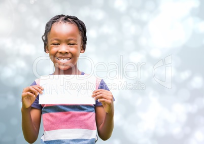 Kid holding a paper smiling against a shining background