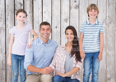 Parent and children smiling against a wood background
