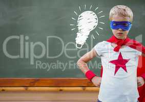 Composite image of superhero kid against blackboard with lightbulb