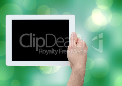 Composite image of hand holding tablet against bright green background