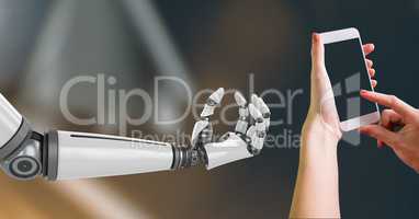 Composite Image of Robotic and Human Hand with phone Interact against dark background